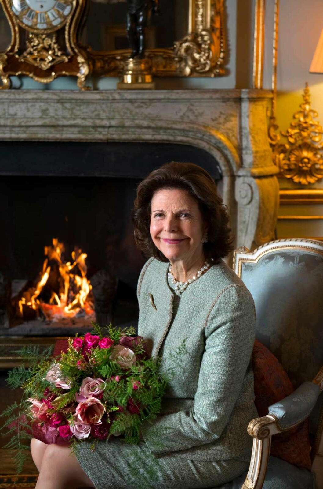 Silvia med vackra blommor framför eldstaden