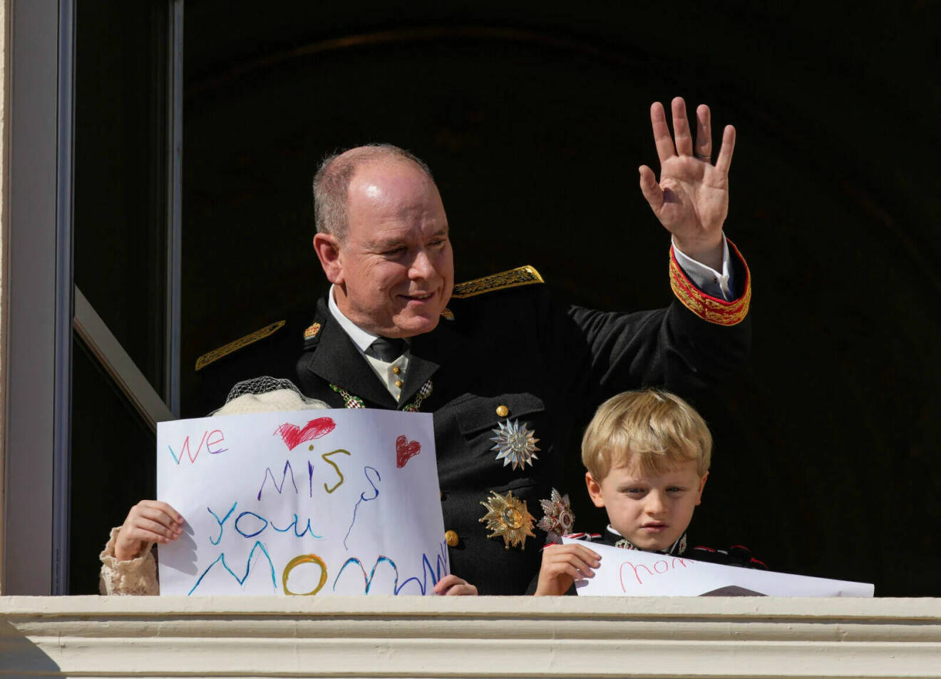 Furst Albert med barnen prinsessan Gabriella och prins Jacques, barnen håller skyltar med texten: "We miss you mommy" efter att Charlene blivit sjuk