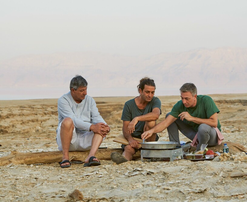 Pappa Seif och bröderna Zafer och Tareq lagar mat på stranden.