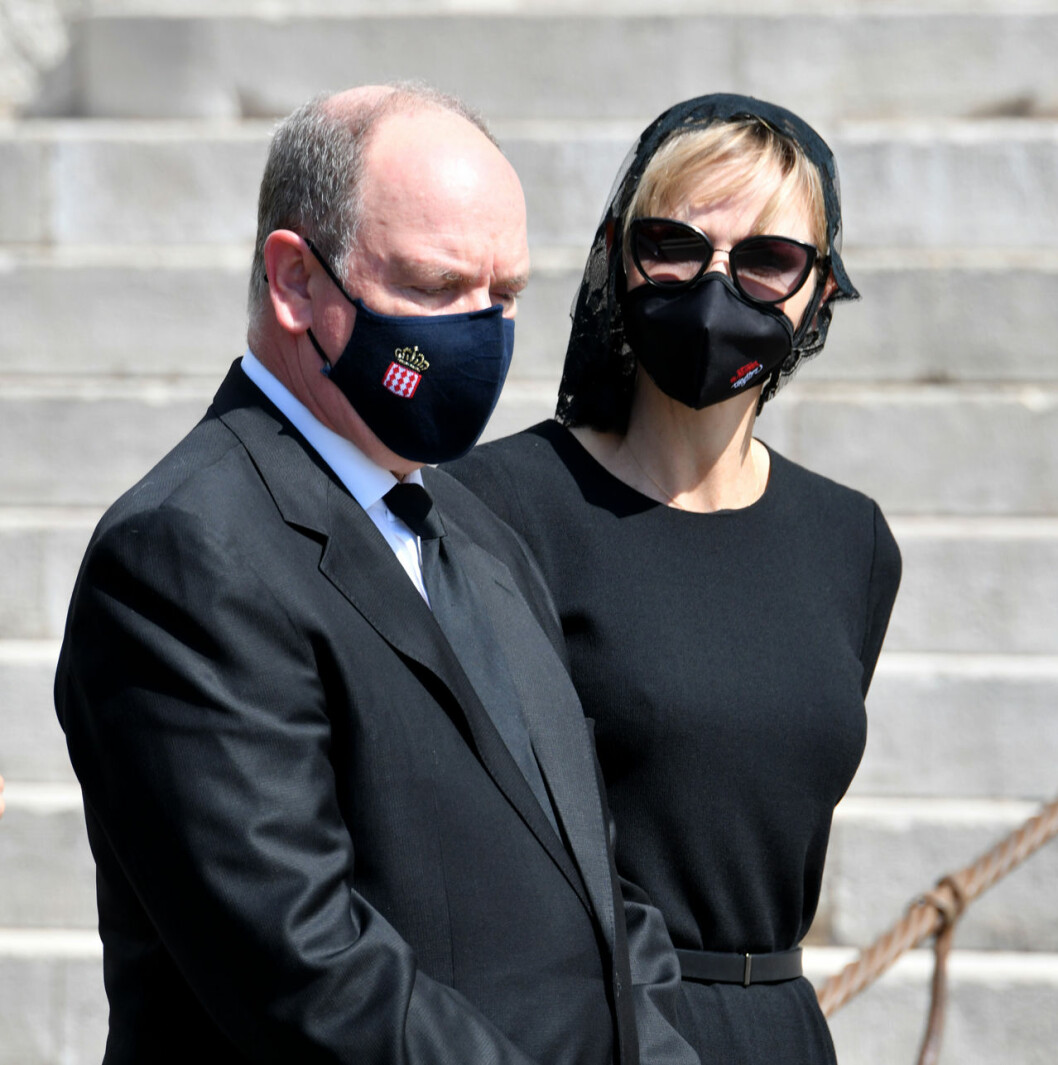 Albert och Charlene. Monacos furstehus har sorg, så där går munskydden i svart. Och missa inte familjevapnet. Albert och Charlene i svarta munskydd