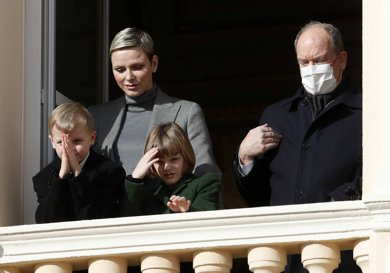 Furstinnan Charlene, furst Albert med munskydd och barnen prins Jacques och prinsessan Gabriella på en balkong