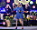 Pernilla Wahlgren står på scen på Allsång på Skansen med en mikrofon i handen och en blå klänning