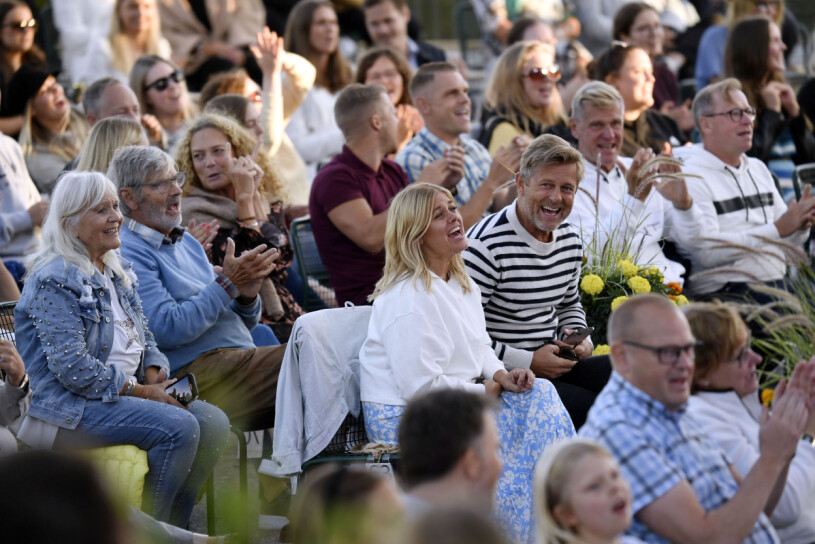 ...och att sitta i publiken! Pernilla Wahlgren skrattar i publiken till Allsång på skansen bredvid sin bror Niklas Wahlgren. Bakom henne sitter föräldrarna Christina Schollin och Hans Wahlgren