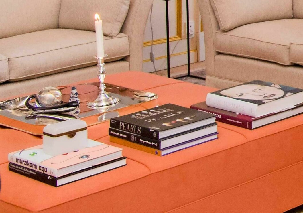 Den danska puffen går i orange, men annars hittar man samma coffee table-böcker och samma ljusstakar och askar. Puffen i ett av kronprinsessan Marys och kronprins Frederiks vardagsrum på Amalienborg.