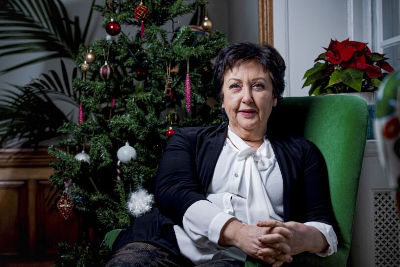 Årets julvärd i SVT Babben Larsson i en grön soffa framför en julgran.