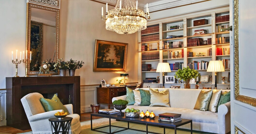 Vy över det hemtrevliga biblioteket med öppen spis i Älvdalsporfyr. I hörnet ser vi Daniels skrivbord. Biblioteket på Haga slott