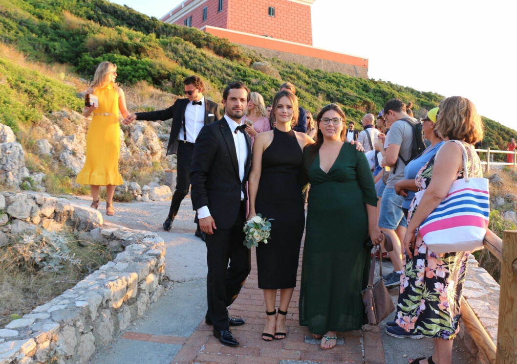 Dags för gruppfoto. I bakgrunden skymtar fyren Faro di Punto Carena. Prins Carl Philip och prinsessan Sofia under vännernas bröllop vid fyren Faro di Punto Carena.
