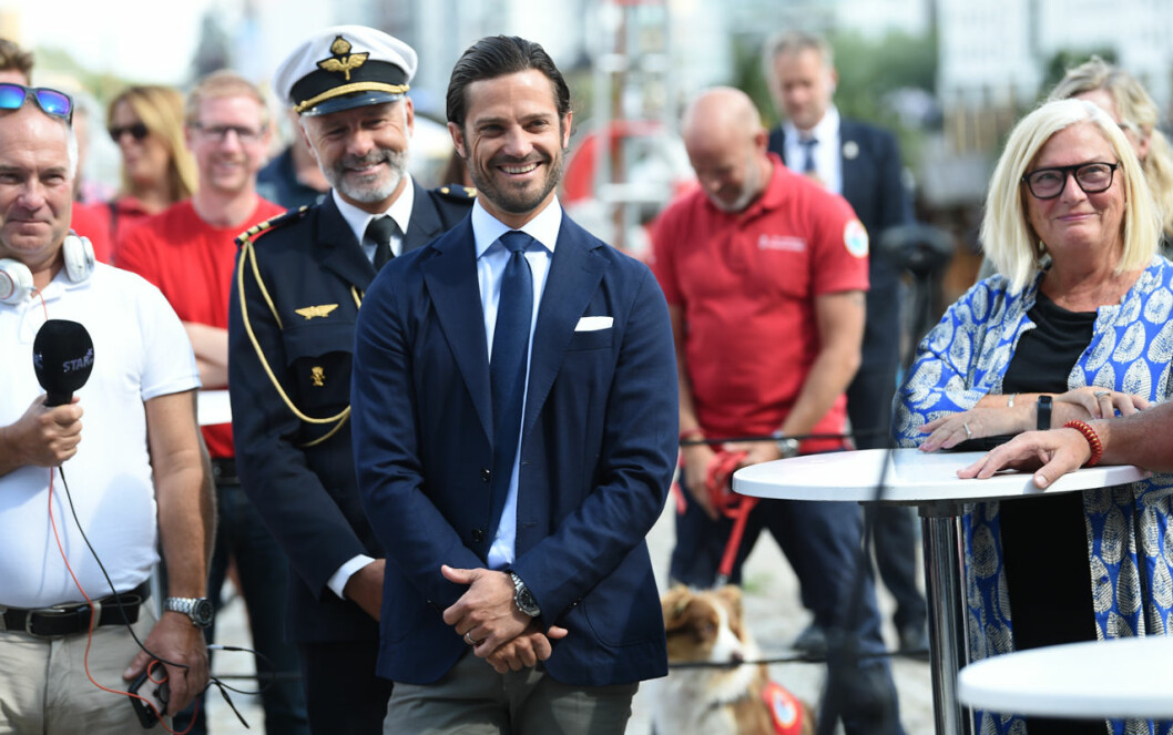 Det var en solbränd och avspänd prins som tog sig an dagens uppdrag. Prins Carl Philip är tillbaka efter semestern. Till vänster ser du hans adjutant.