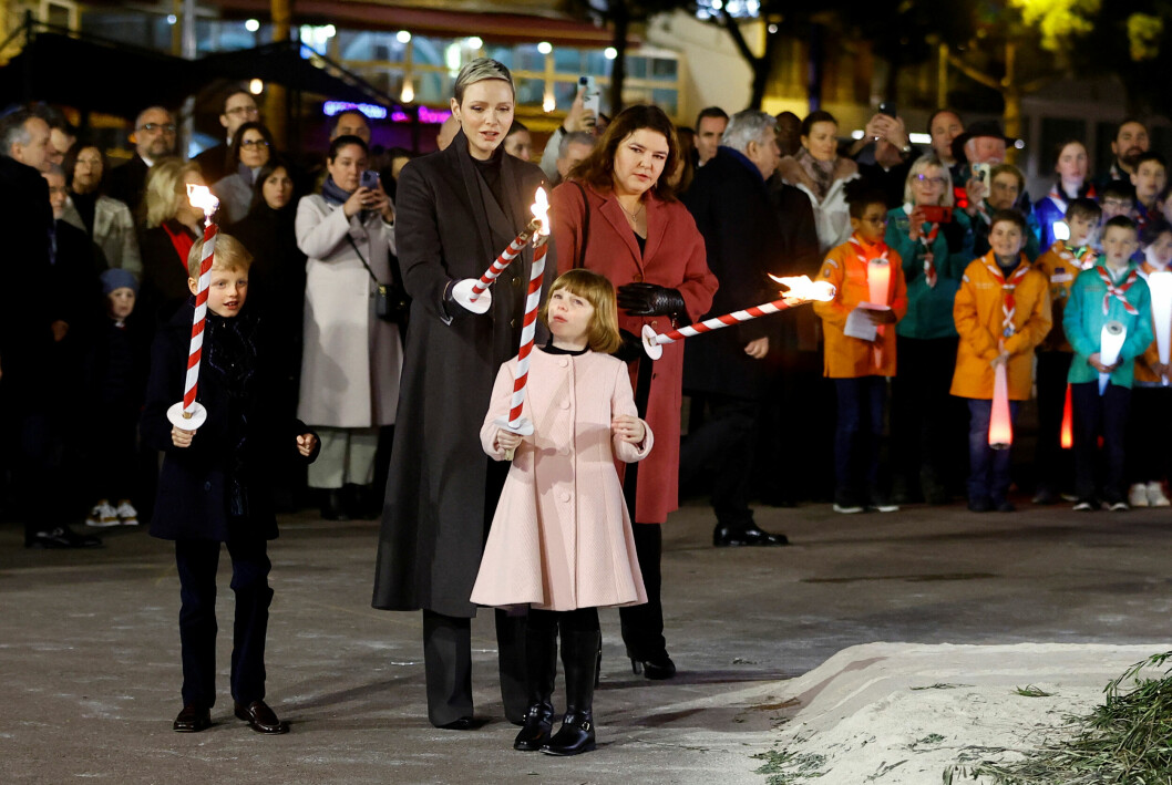 Furstinnan Charlene och tvillingarna prins Jacques och prinsessan Gabriella firar Sainte Devote i Monaco med facklor i händerna