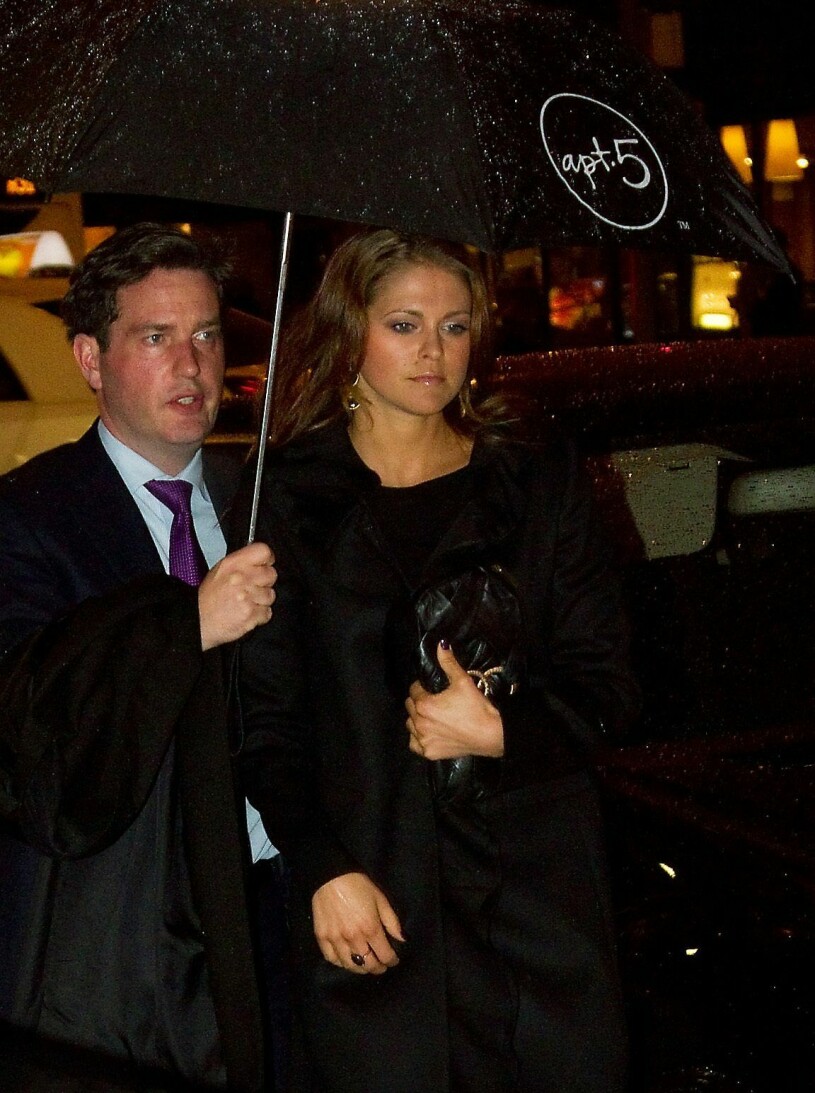 Chris O'Neill bär ett paraply över prinsessan Madeleine
