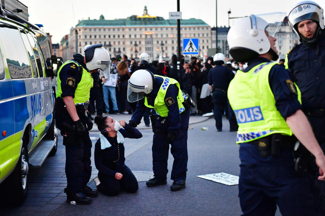 Polisen med en av demonstranterna. Demonstrationer framför slottet.