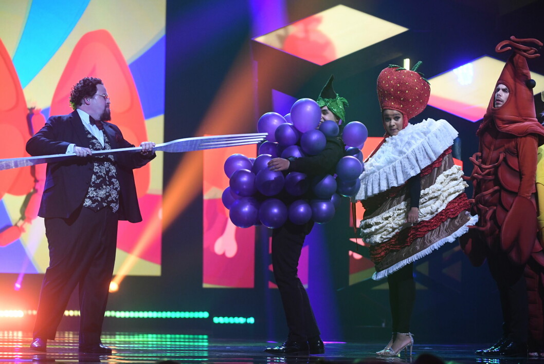 Edward Blom på scen i Melodifestivalen 2018 med dansare utklädda till mat