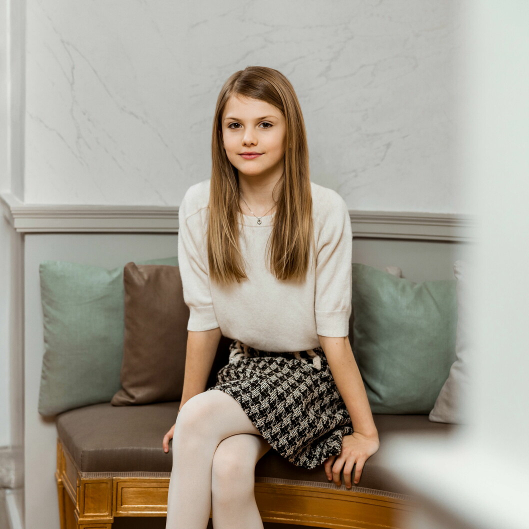 Prinsessan Estelle sitter på en bänk och ler