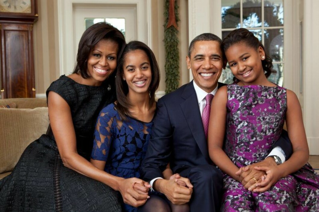 Den här bilden är från 2011 och familjen hade då hunnit att bo i Vita huset i två år. Från vänster: Michelle, Malia, Barack och Sasha. Michelle, Malia, Barack och Sasha Obama. sitter i en soffa finklädda och ler.