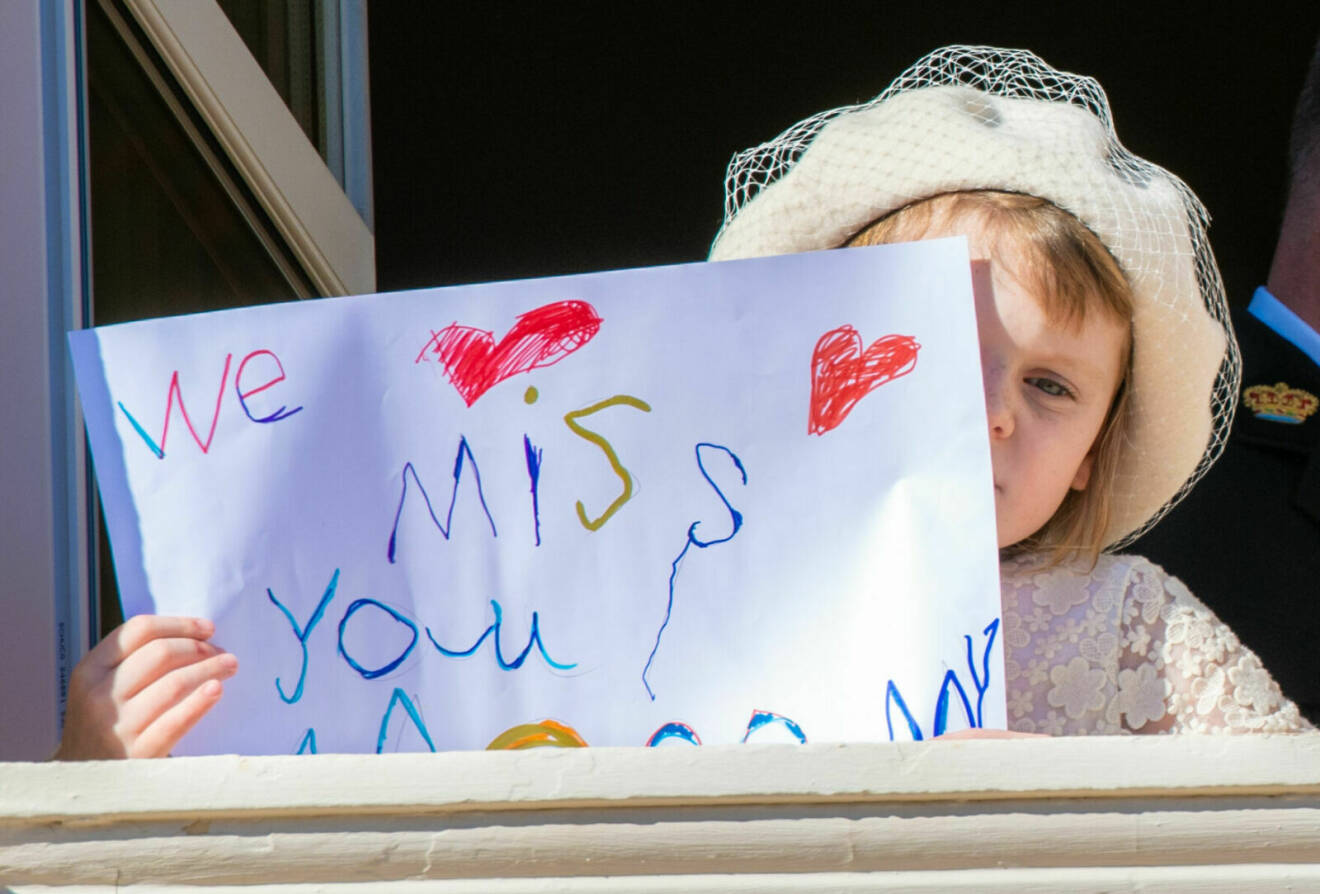 Prinsessan Gabriella med en skylt där det står: "We miss you mommy"