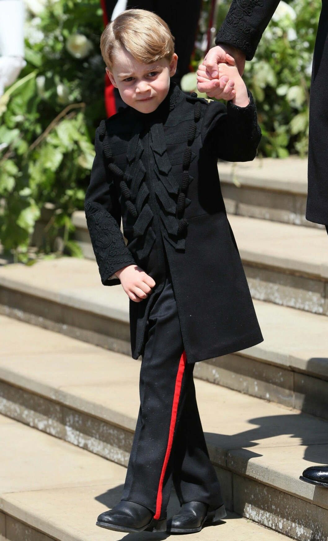 En liten miniversion av pappa och farbror Harry. Brudnäbben prins George i skräddarsydd uniform från Saville Row i London. Brudnäbben prins George i en skräddarsydd uniform från Saville Row i London.