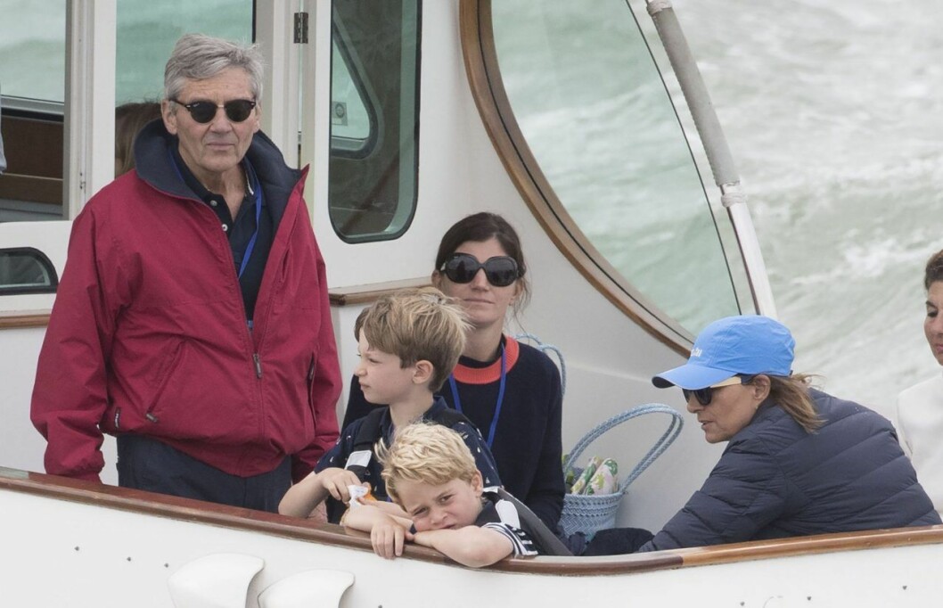 George lutar sig mot räcket och i bakgrunden syns morfar Michael Middleton. Till höger i bild sitter även mormor Carole Middleton. George lutar sig mot räcket och i bakgrunden syns morfar Mike Middleton. Till höger i bild sitter även mormor Carole Middleton.