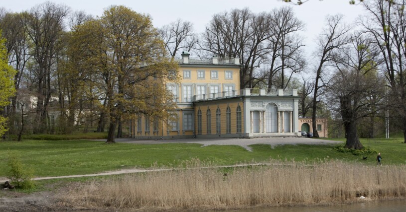 Ser du Haga slott – eller ”Barnens palats” – bakom träden? Här, i Gustav III:s paviljong vid strandkanten, bodde föräldrarna. Men det blev för trångt när tredje barnet anlände, och lösningen blev alltså ett slott till (!). Gustav III:s paviljong