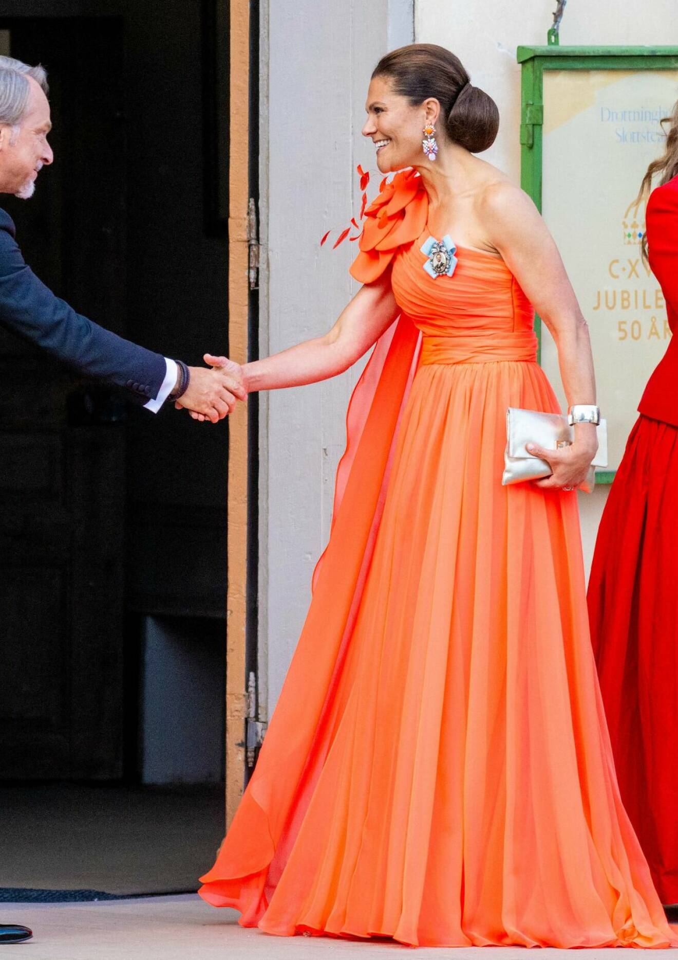 Kronprinsessan Victoria i orange eller korallfärgad aftonklänning designad av Christer Lindarw