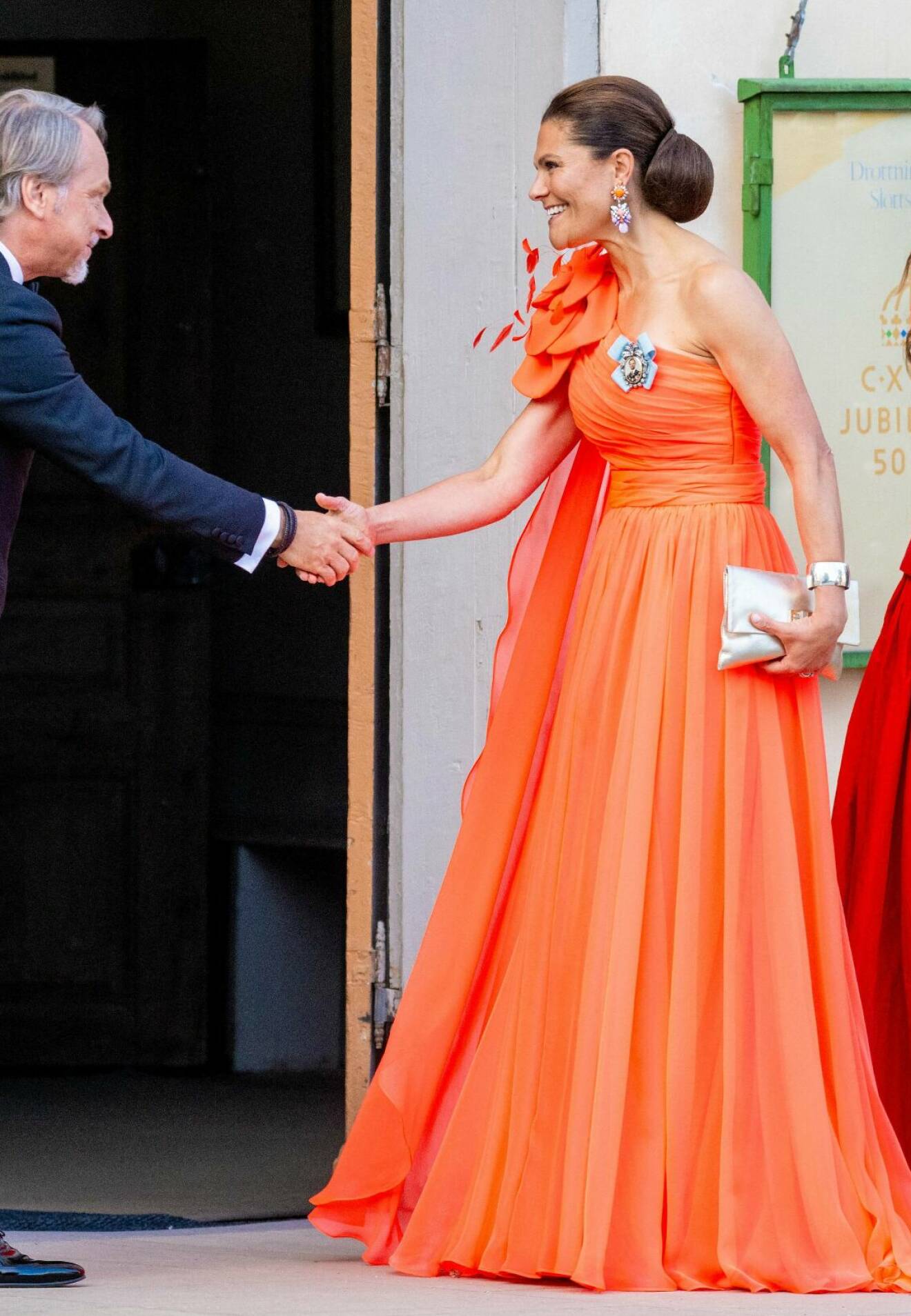 Kronprinsessan Victoria i en orange aftonklänning i design av Christer Lindarw