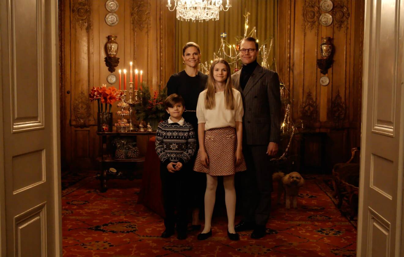 Kronprinsessan Victoria, prins Daniel, prinsessan Estelle, prins Oscar samt hunden Rio framför granen på slottet julen 2023