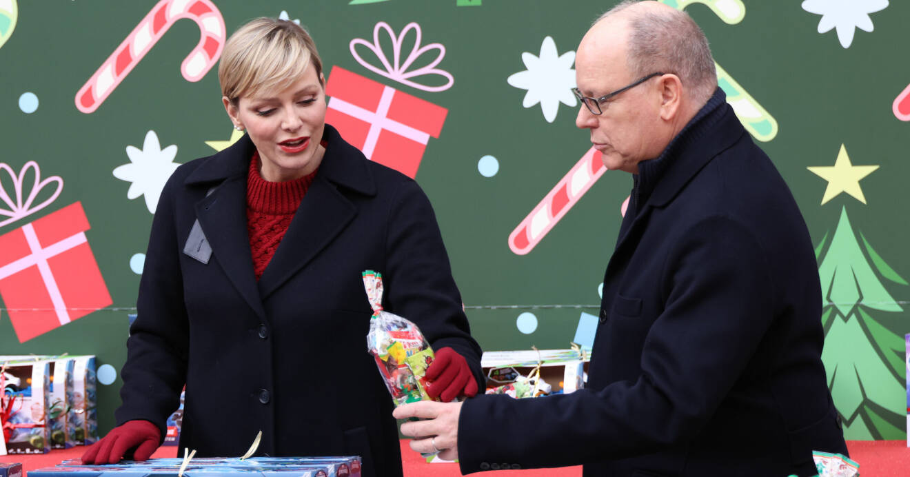 Furstinnan Charlene och furst Albert hjälper varandra dela ut julklappar till barn