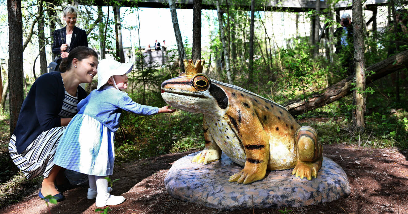 Prinsessan Estelle klappar en grodskulptur på sitt första officiella uppdrag i Östergötlands län