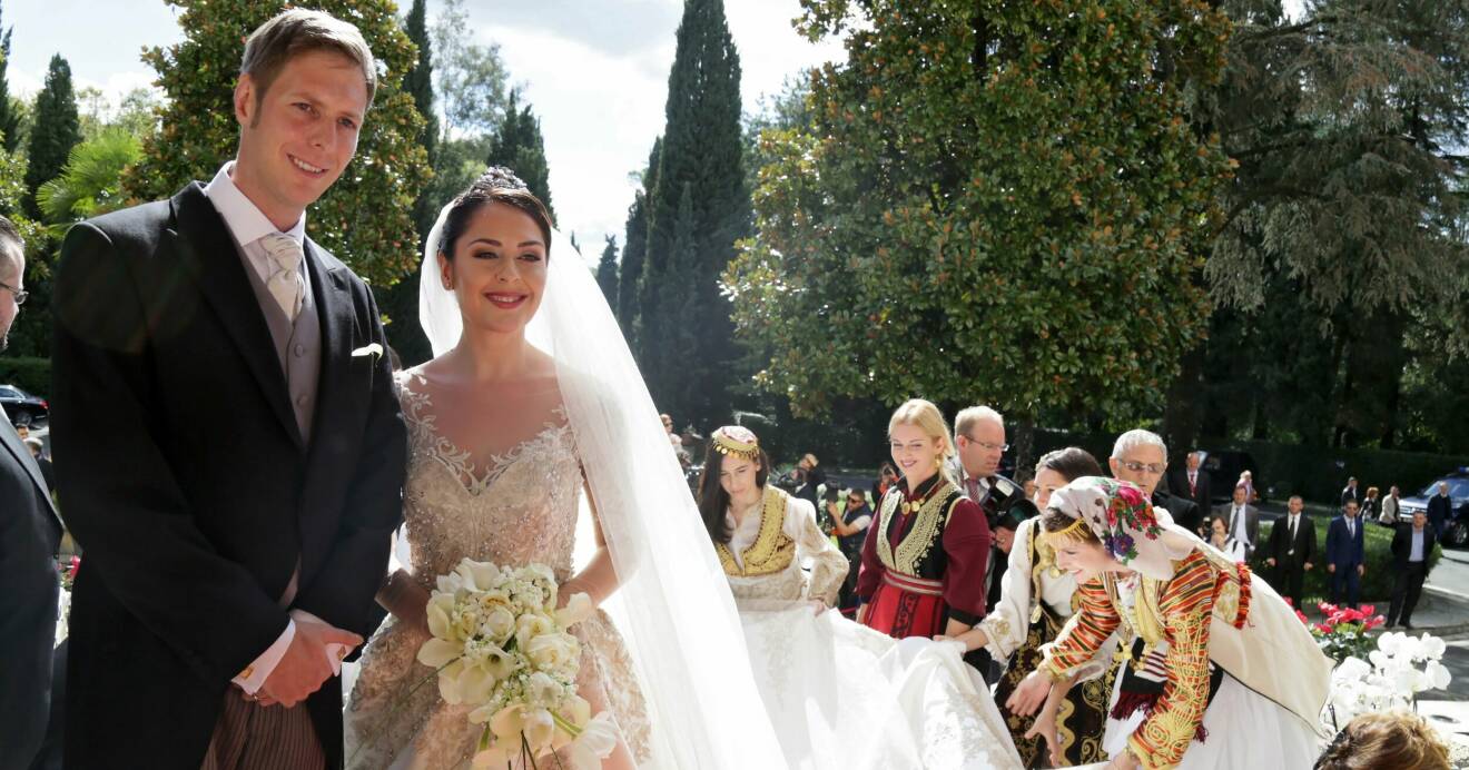 Kronprins Leka och kronprinsessan Elia står bredvid varandra och ler på sin bröllopsdag