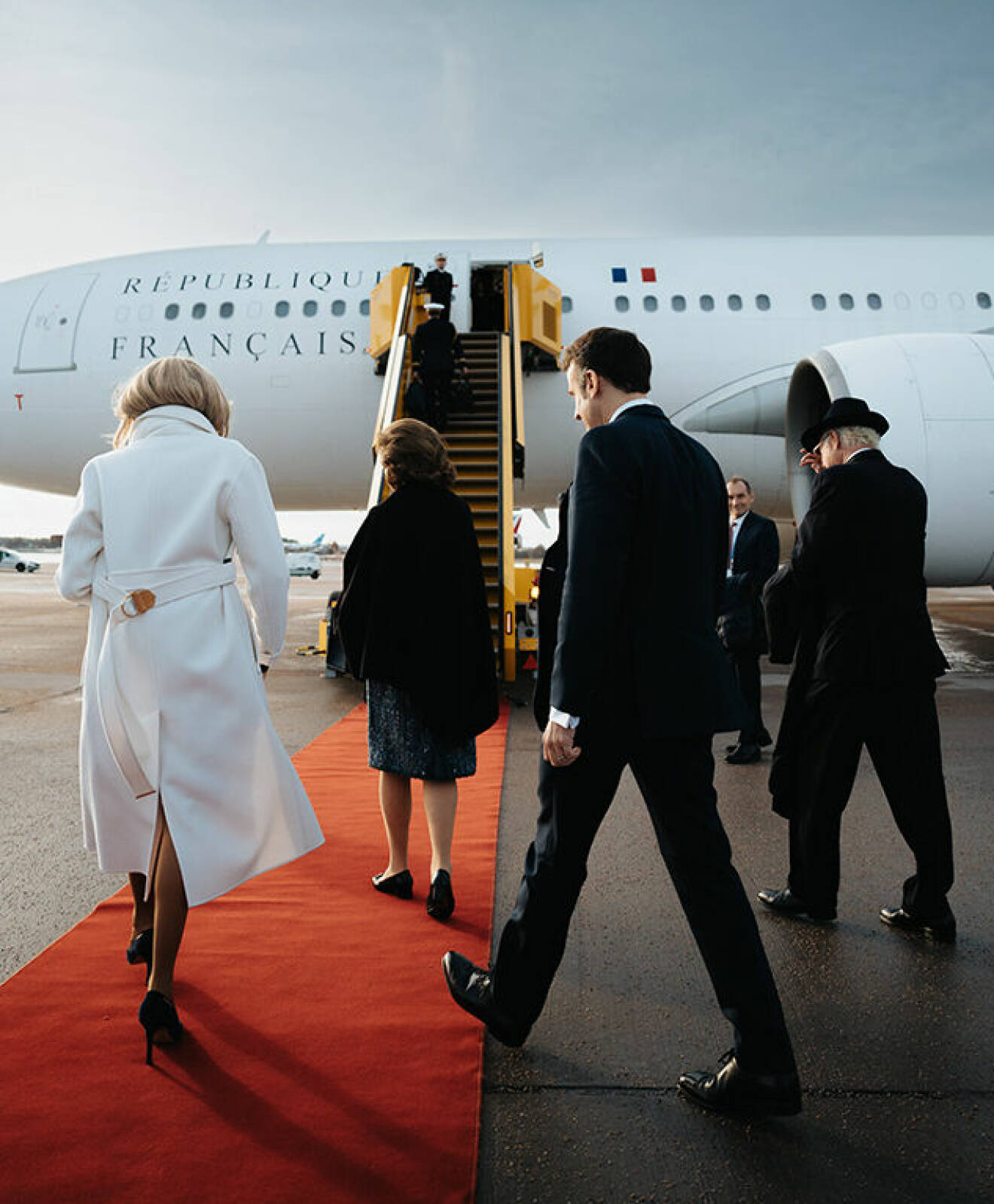 Kungen, drottning Silvia med paret Macron på väg att gå ombord på franska statsplanet