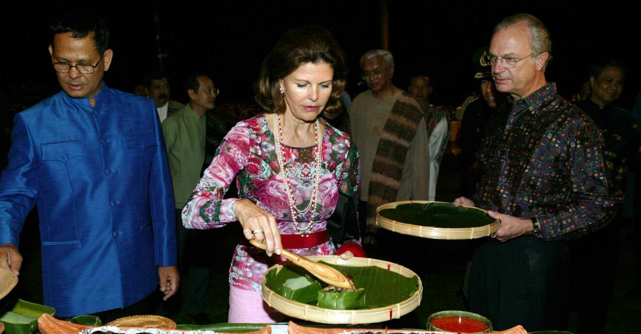 Drottning Silvia håller i en stor tallrik med mat