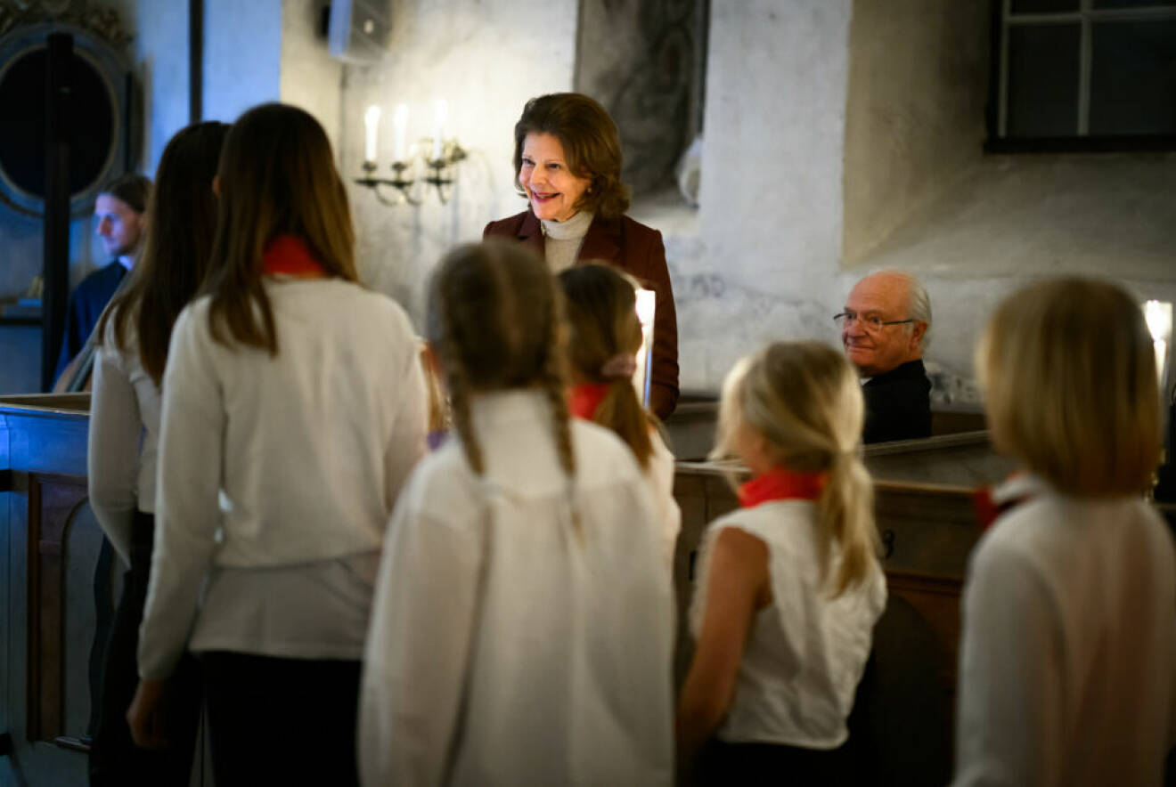 Drottning Silvia och kungen hälsar på barnkören under drottning Silvias födelsedagskonsert i Lovö kyrka