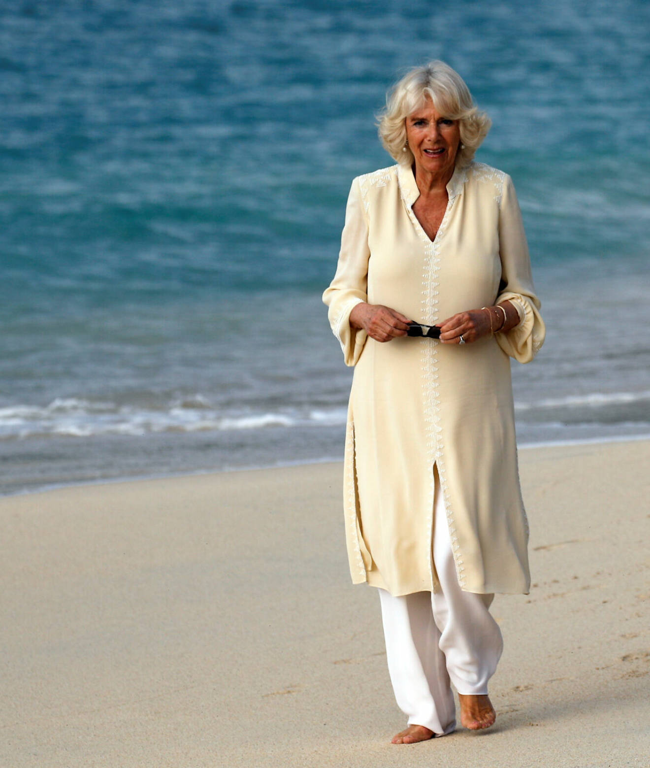 Drottning Camilla barfota på en strand