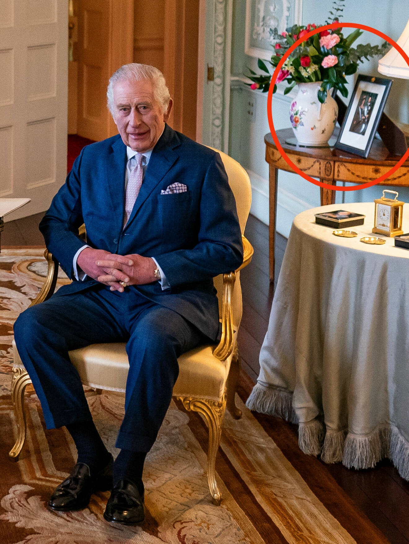 Kung Charles på Buckingham Palace med det officiella porträttet på kungen och drottning Silvia