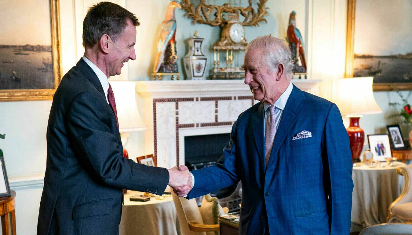 Kung Charles skakar hand med finansminister Jermey Hunt