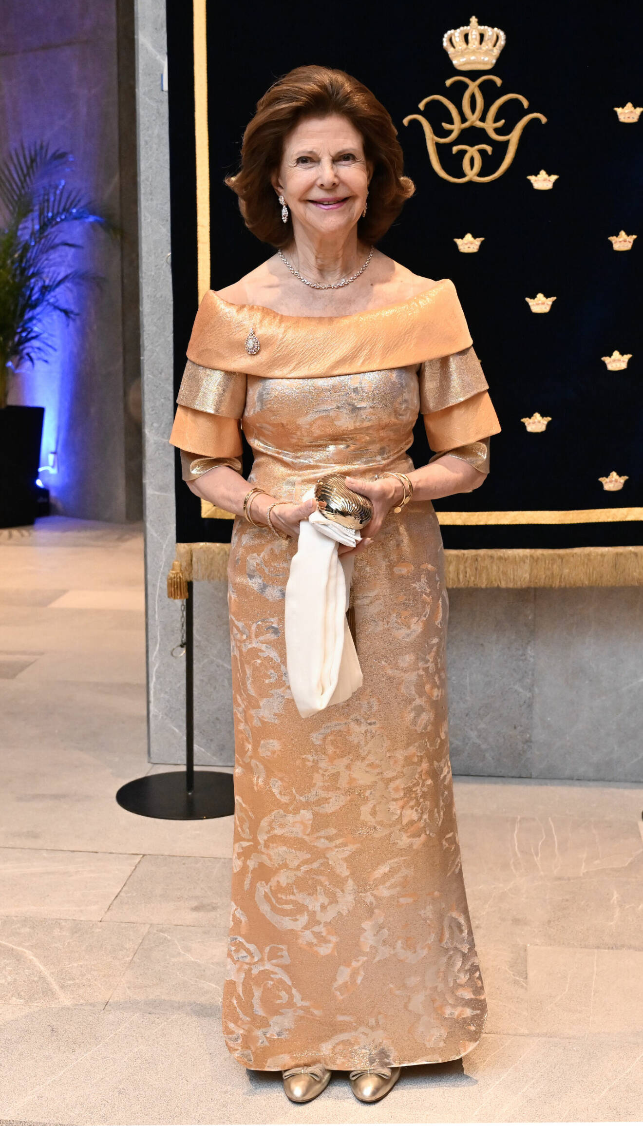 Drottning Silvia i aftonklänning i aprikos och guld