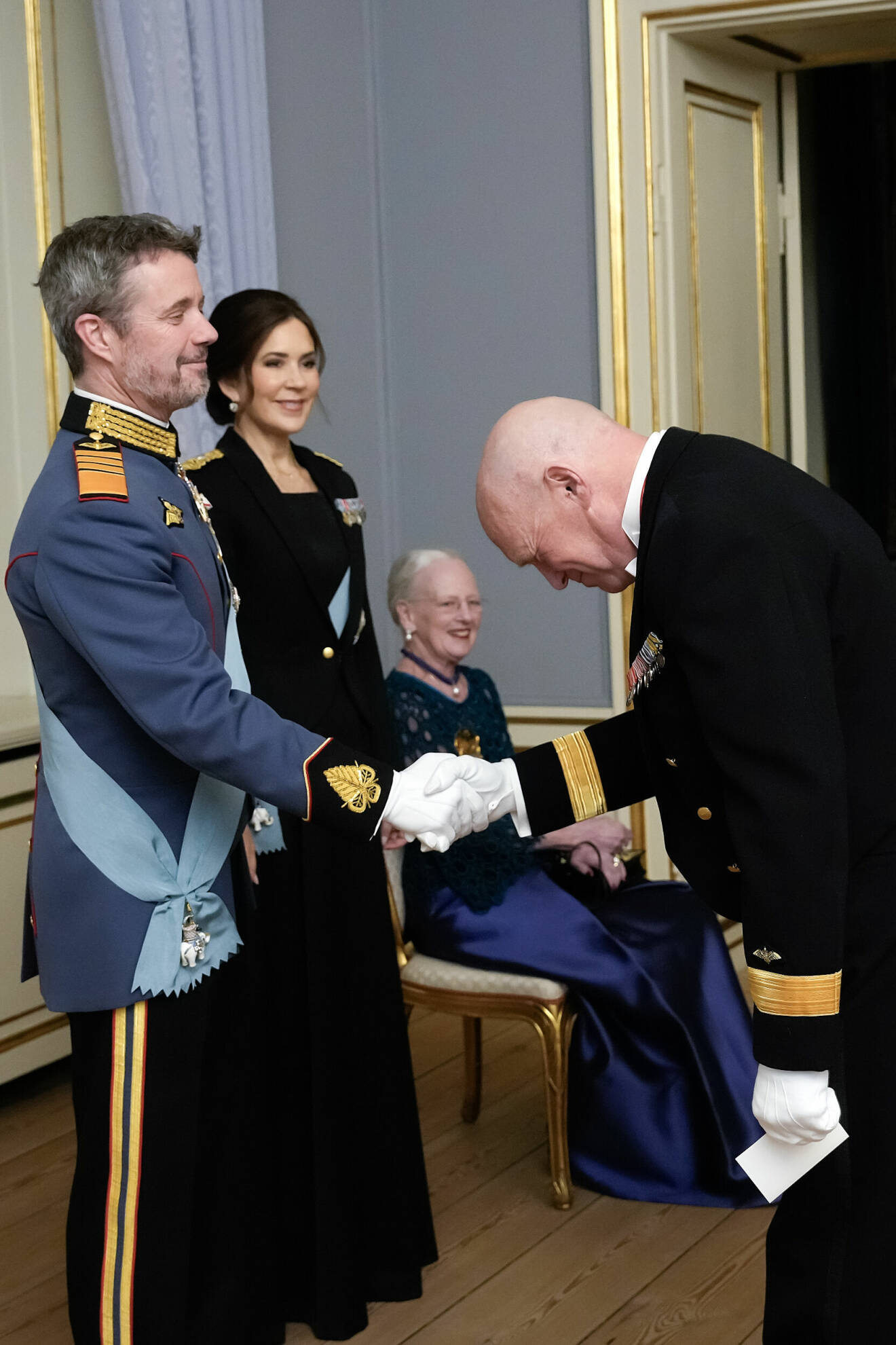 Kung Frederiks uniform och drottning Marys uniform vid Hedersteckenmiddagen 2024 på Amalienborg