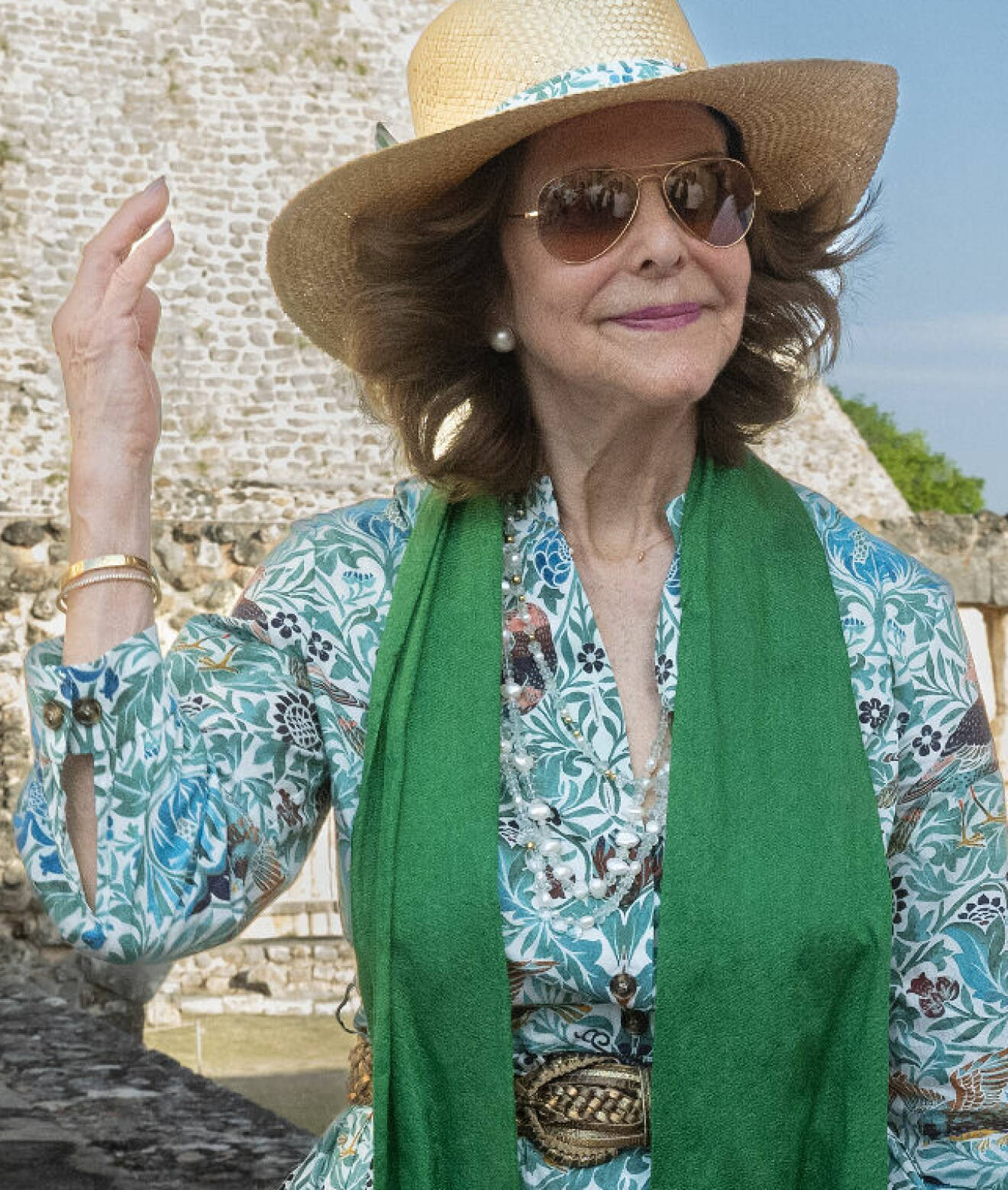 Drottning Silvia i solhatt och grön klänning under besöket i Uxmal i Mexiko