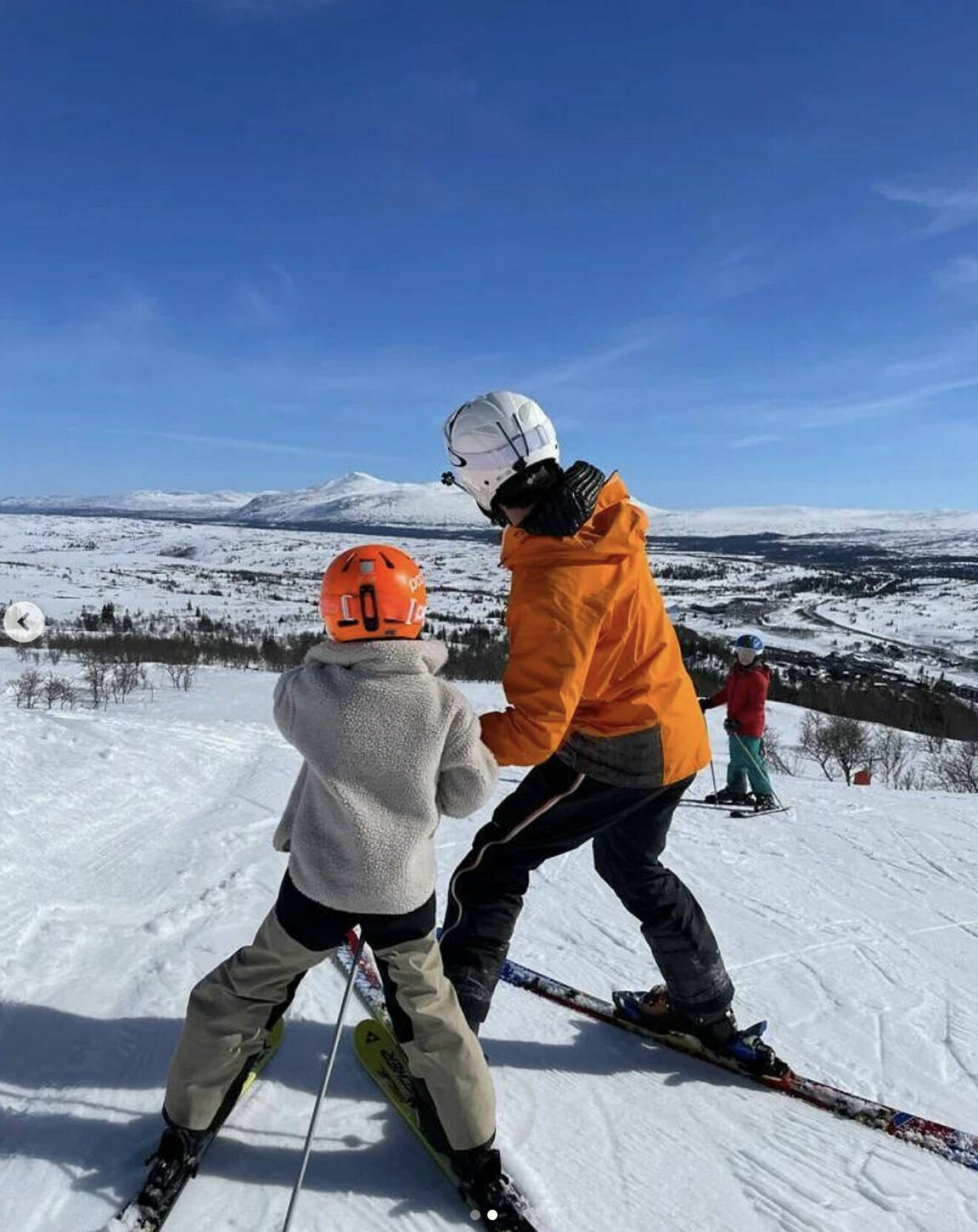 Prins Carl Philip åker skidor med ett av barnen i fjällen