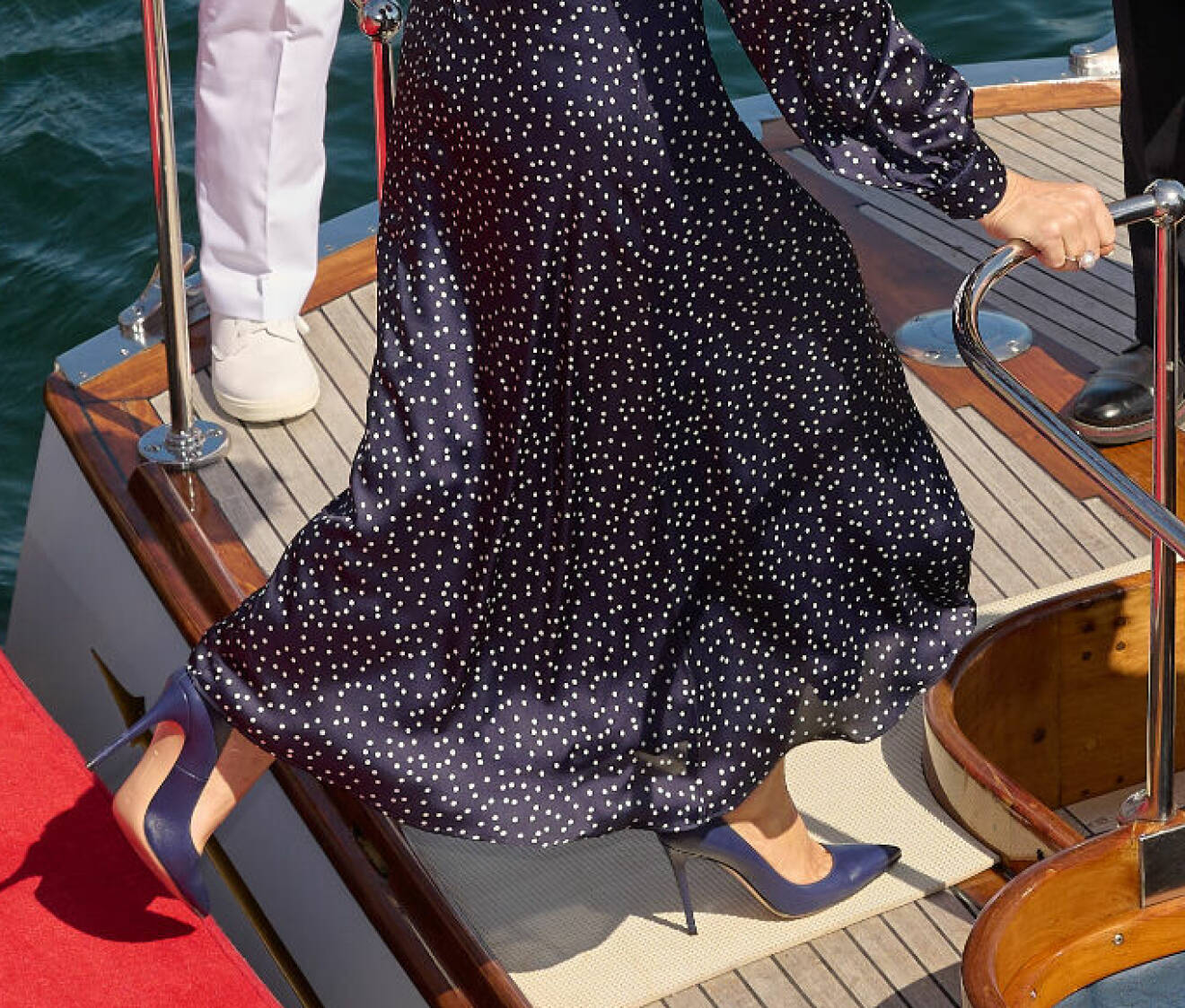Drottning Mary går ombord på en båt i högklackat