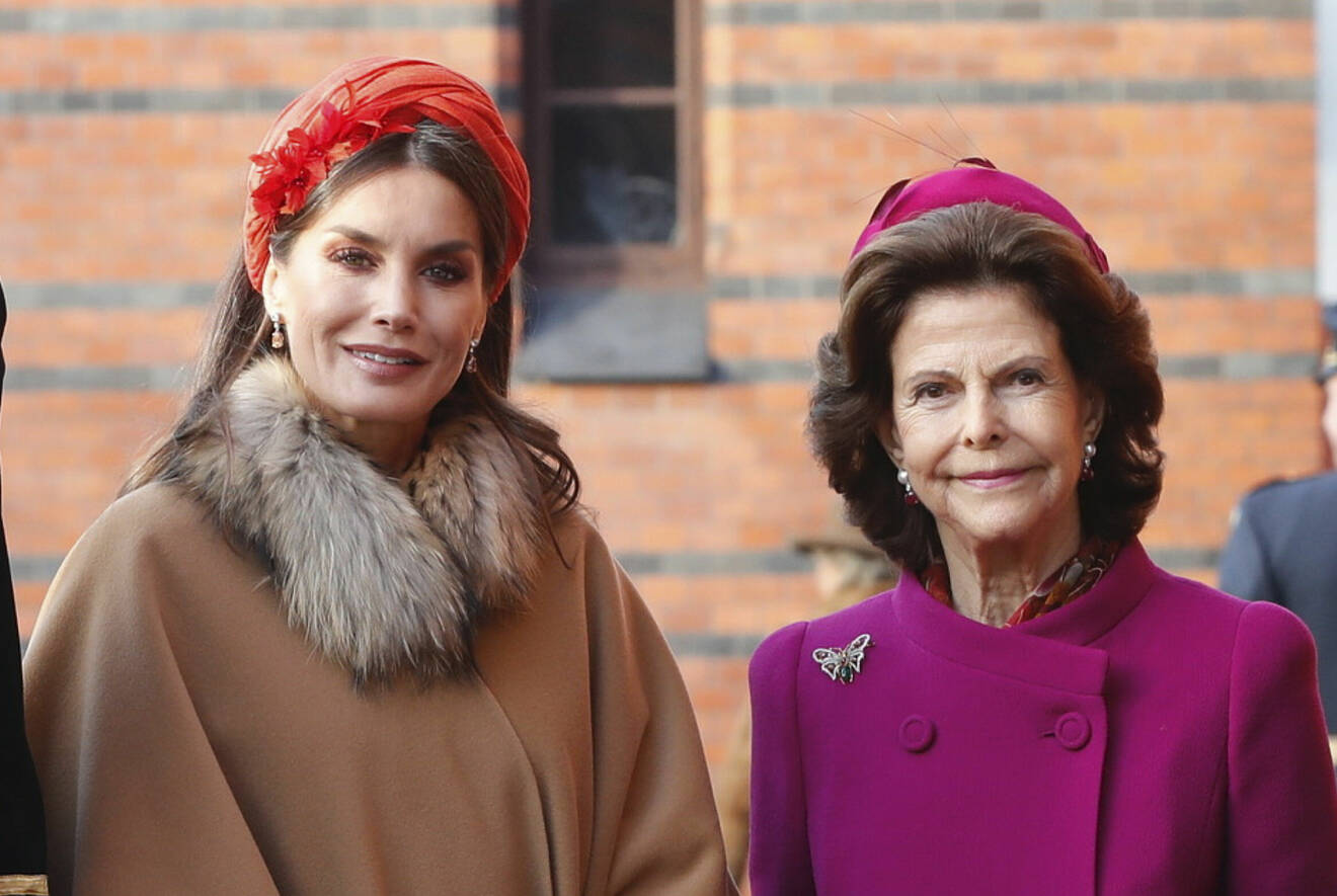 Drottning Letizia i röd coiffe och drottning Silvia i ceriseröd hatt från modisten Kerstin Carlefalk och hennes hattateljé Hatteljén i Midsommarkransen