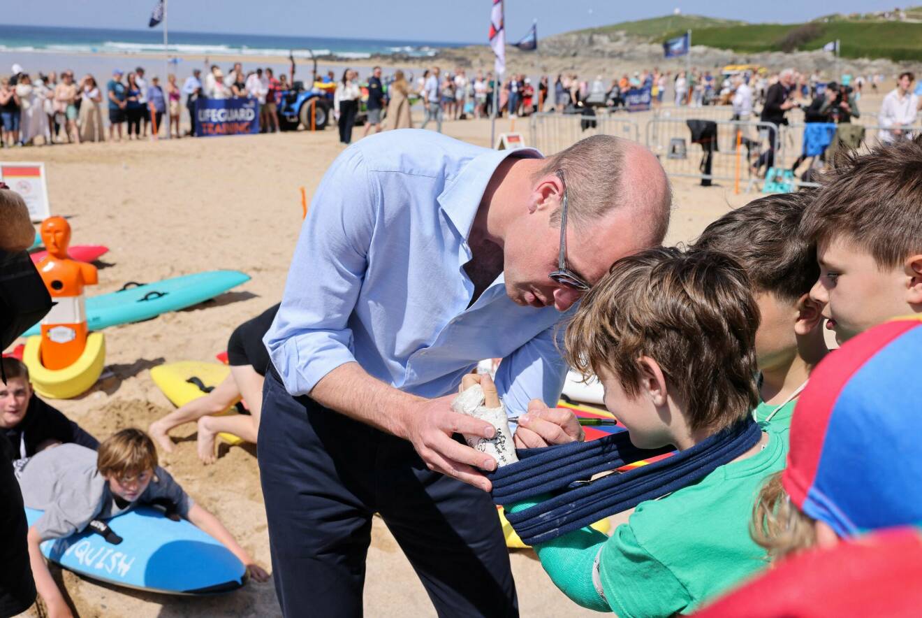Prins William signerar en pojkes gips