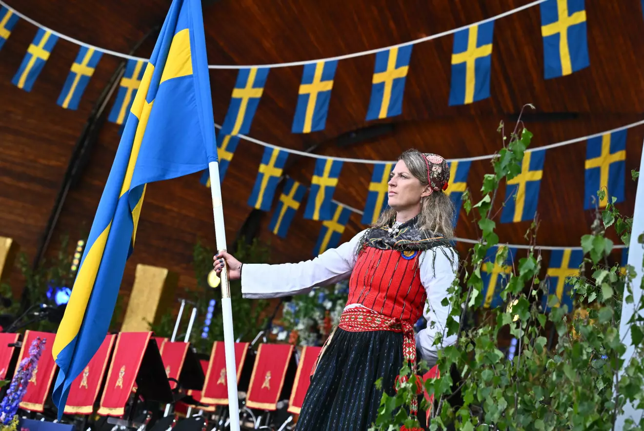 Fanbärare med svenska flaggan under torsdagskvällens nationaldagsfirande på Skansen i Stockholm