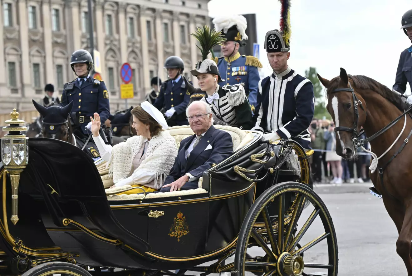 Drottning Silvia och kung Carl Gustaf åker i kortege med häst och vagn genom Stockholm