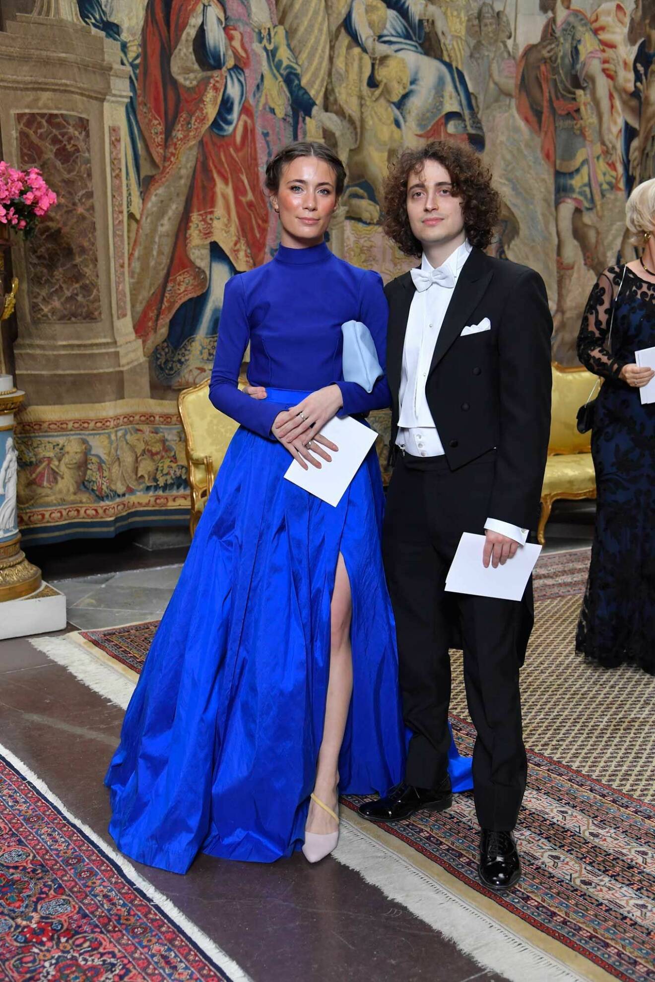 Kompositören Jacob Mühlrad och Filippa Fuxe anländer till en representationsmiddag på Stockholms slott.