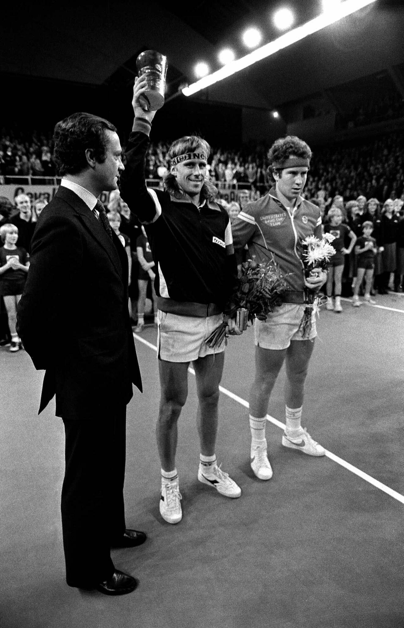 Björn Borg firar segern över finalmotståndaren John McEnroe, till höger, i Stockholm Open 1980. Till vänster gratulerar kung Carl XVI Gustaf.