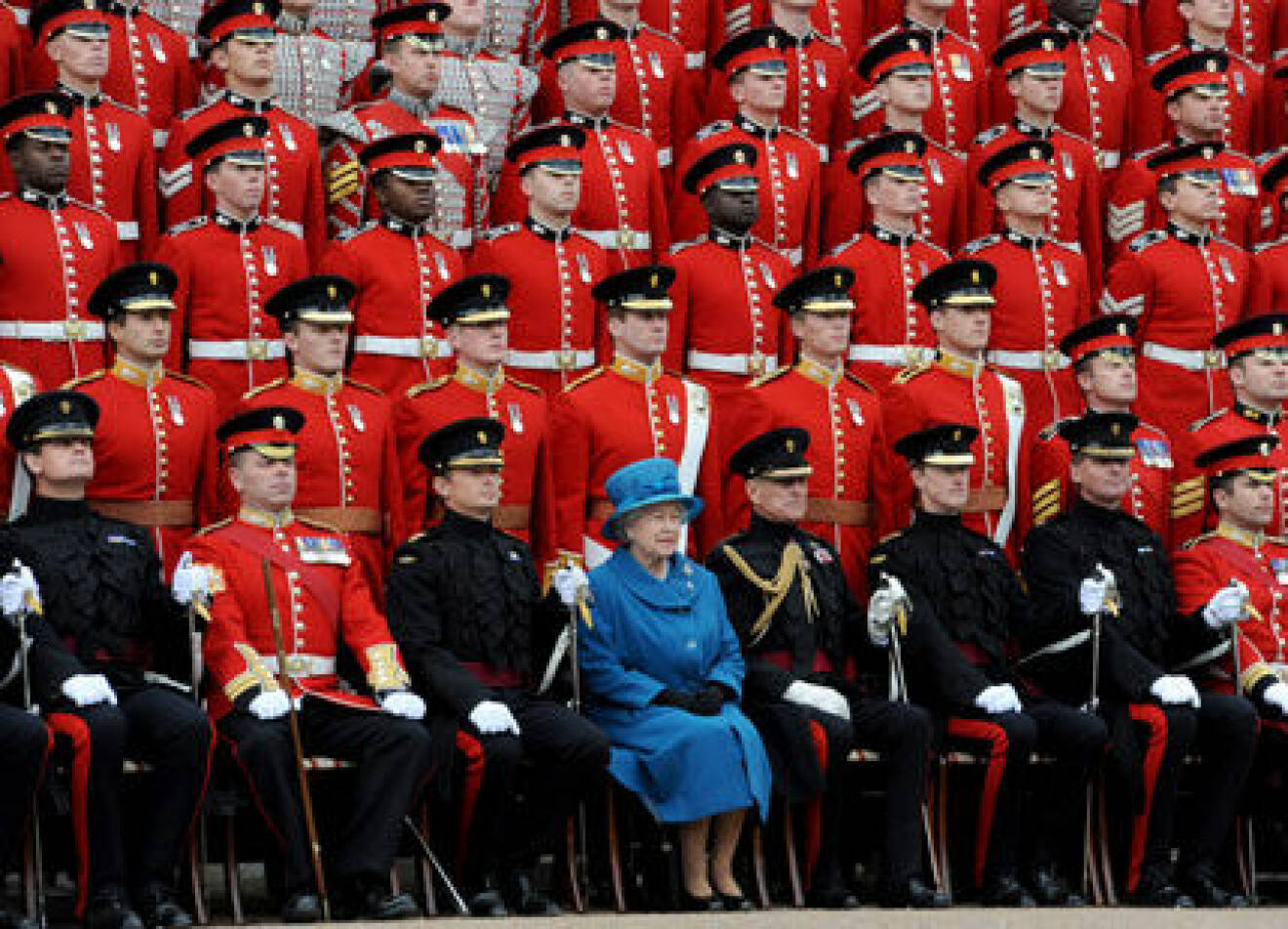 Drottning Elizabeth omgiven av färgglada miliärer.
