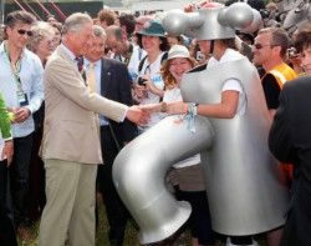 Prins Charles skakar hand med en vattenkran för Wateraid-kampanjen.