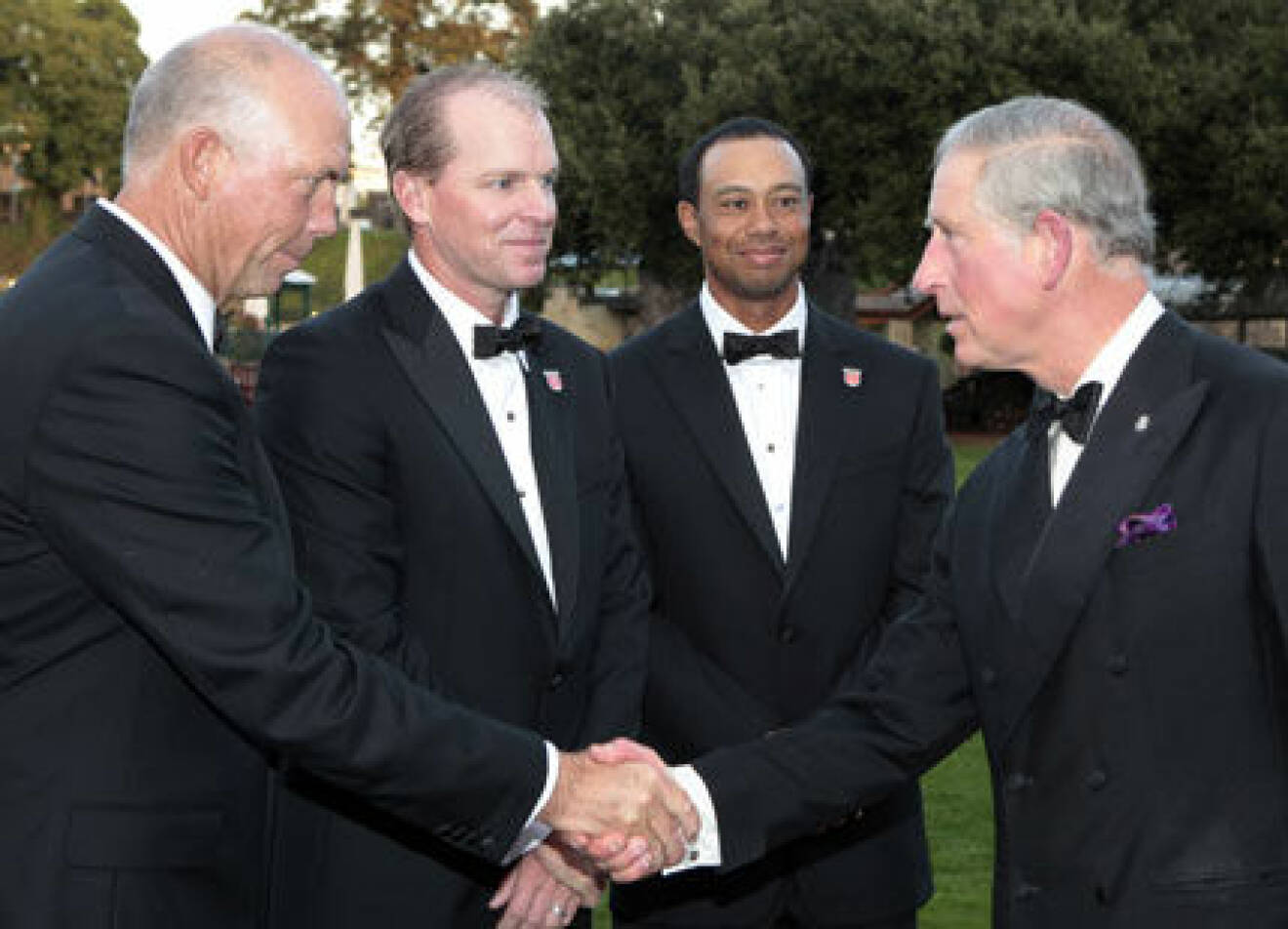 Prins Charles hälsar på golfspelarna, däribland Tiger Woods.