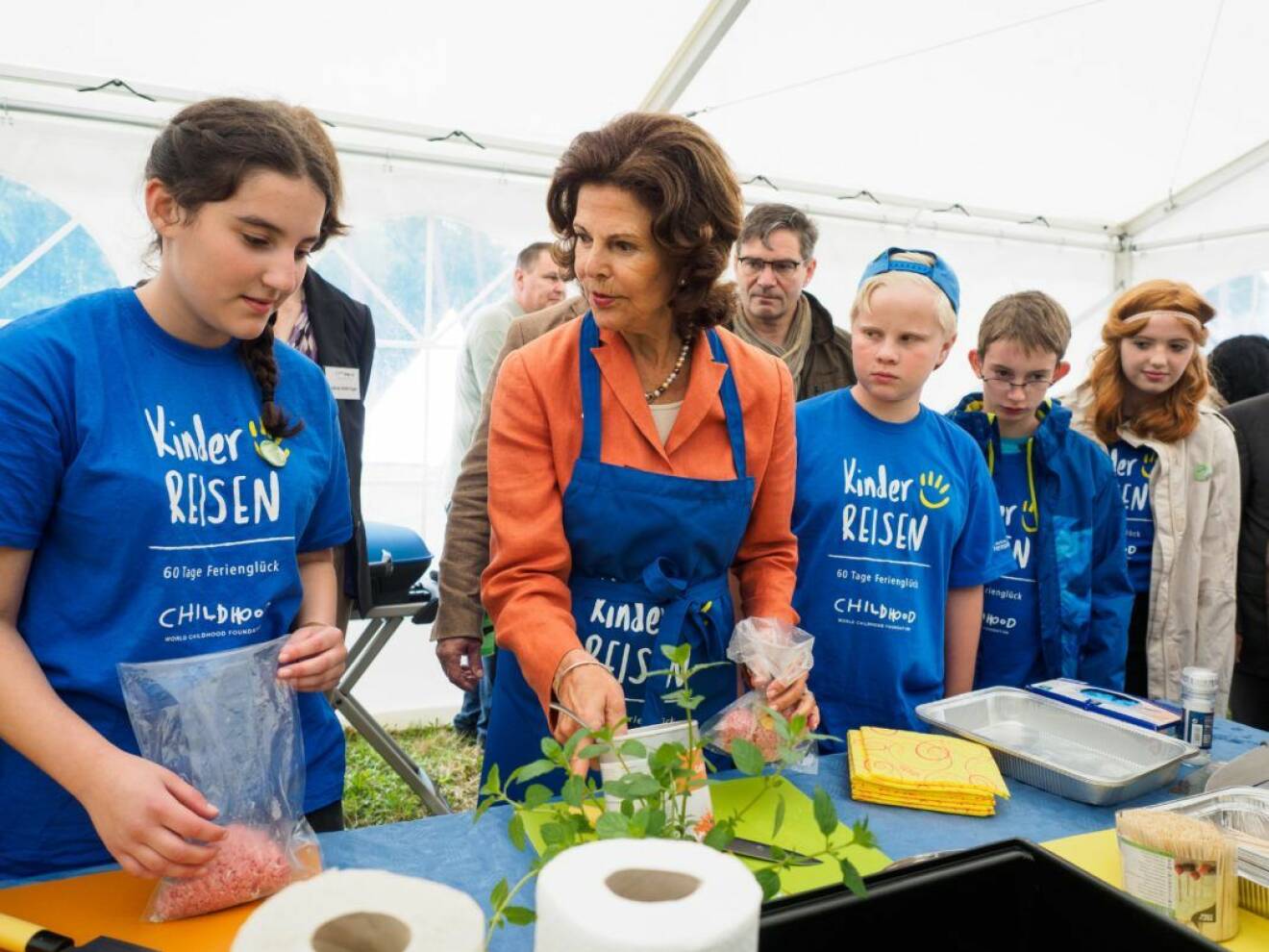 Queen Silvia of Sweden prepares food with children from the summer camp at the Erlebnispark Thurn adventure park in Heroldsbach, Germany, 2 August 2016. Queen Silvia of Sweden visited the children's holiday camp of the German TV lottery at the Schloss Thurn adventure park. PHOTO: NICOLAS ARMER/DPA (c) DPA / IBL Bildbyrå