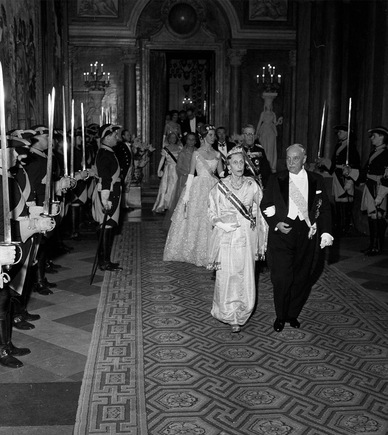 Gästerna på väg till middagen med drottning Louise och förbundspresident Schärf i spetsen följda av kung Gustaf VI Adolf med prinsessan Margaretha, prins Bertil med fru Erlander.